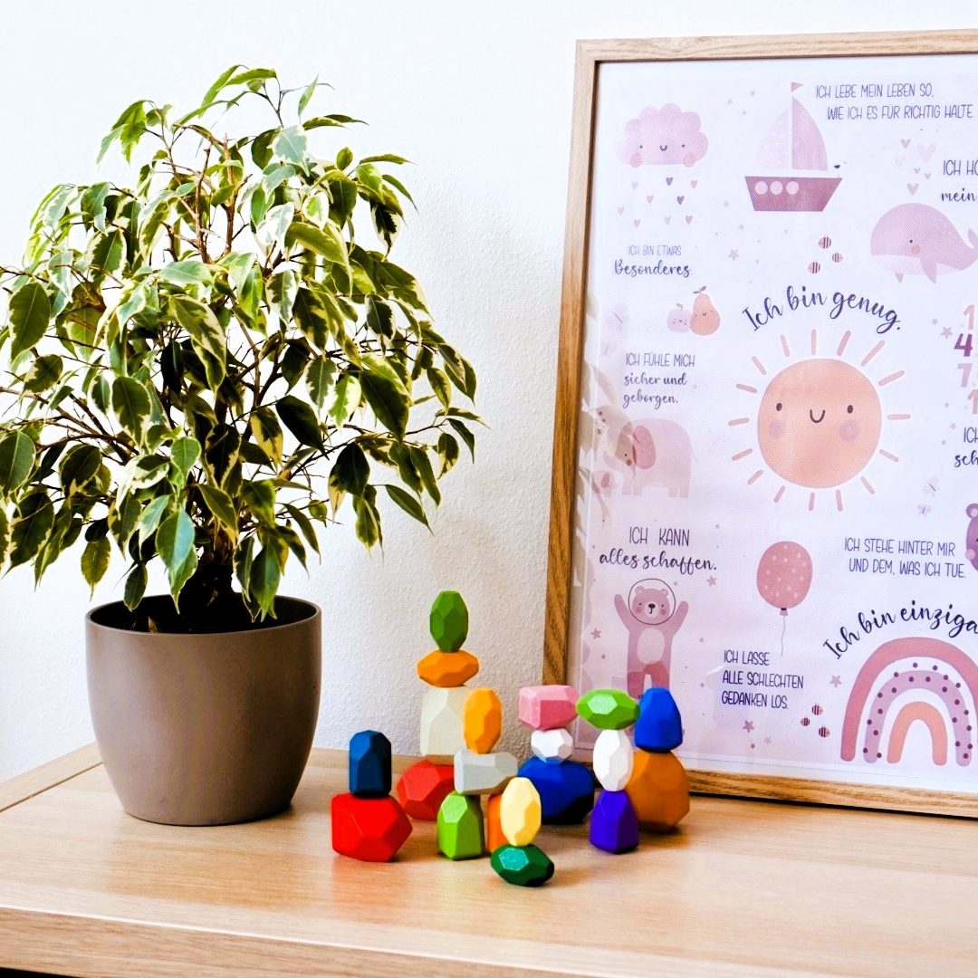 Pflanze in einem Blumentopf neben bunten Bauklötzen und einem bunten Wandbild.